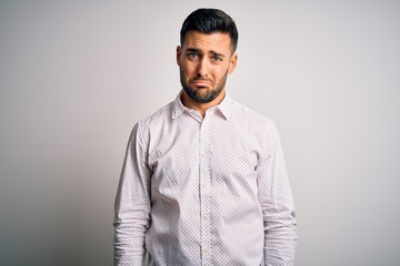 Fototapeta premium Young handsome man wearing elegant shirt standing over isolated white background depressed and worry for distress, crying angry and afraid. Sad expression.