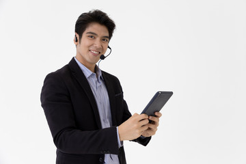 Young call center staff talking and provide services to customers via headphones and microphone cable with tablet. Professionals with speech, service mind and information recording skills.