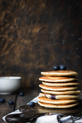 ricotta pancakes with blueberries on a dark wooden background