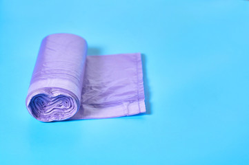 One purple disposable plastic garbage bag on blue background. Copy space