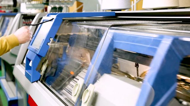 Operator setting automatic knitting machine programme view.