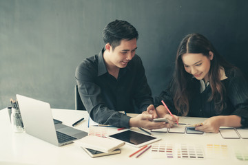 Two graphic designers creative drawing website ux app development and application for mobile phone in the office.