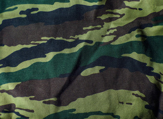 forest camouflage army clothing. Abstract fabric background with pleats. Hunting clothes.