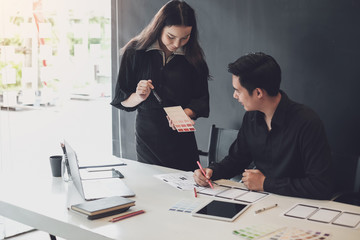 Two graphic designers creative drawing website ux app development and application for mobile phone in the office.