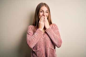 Young beautiful redhead woman wearing pink casual sweater over isolated white background laughing...