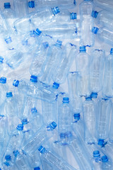 Pile of blue plastic bottles, concept of harm of plastic for ecology and planet, problems of ecology and pollution. Many empty plastic bottles backdrop.