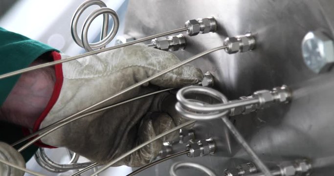 Ingegnere nucleare sta inserendo le sonde della temperatura, o termocoppia nel serbatoio. Effetto Seebeek.