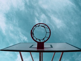 Basketball rim above outdoor court. Basketball court under sky