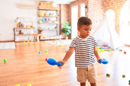 Beautiful toddler boy playing bowling at kindergarten
