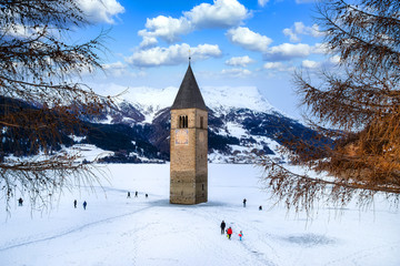 Winter landscape in the Alps with the famous sunken church tower in Reschensee (Resia lake), On the border between the South Tyrol (Italian Alps) and Austria.