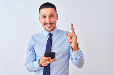 Young handsome business man using smartphone over isolated background surprised with an idea or question pointing finger with happy face, number one