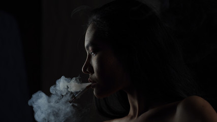 Asian woman inhaling and cigarette vaping. Female secretly smoking in bathroom at home. Concept of quit smoking and anti cigarette.