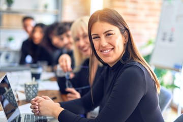 Group of business workers sitting in line with smile on face. Looking at the camera, young beautiful woman smiling at the office