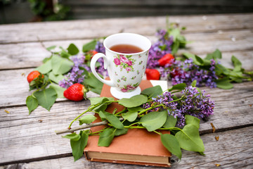 Morning beverage in the garden with flowers, fruit and tea