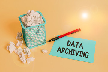 Word writing text Data Archiving. Business photo showcasing to secure and to store data for long term retention crumpled paper trash and stationary with note paper placed in the trash can