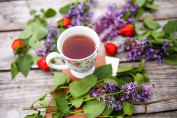 Morning beverage in the garden with flowers, fruit and tea