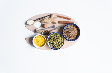 Spice mix adwiya in vintage spoons and bowls on  wooden palette on white background with copy space