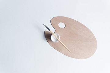 Artist brush and paint on wooden clean palette on white background