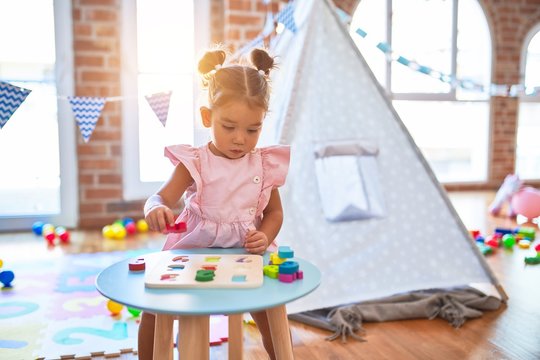 Young beautiful toddler learning mathematics playing with maths game at kindergaten