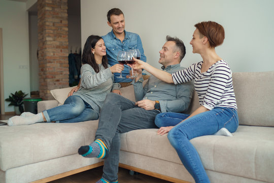 Cheerful Friends Drinking Wine And Having A Good Time At Home