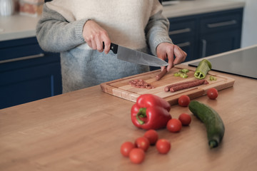 Woman's hands cutting vegetables in a kitchen
