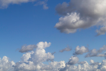 White cumulus clouds on blue sky.