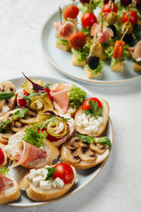portioned snacks canapes and sandwiches with meat, cheese and vegetables