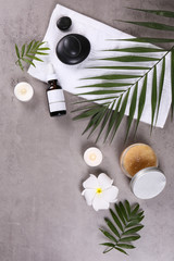 Spa procedure attributes, face and body cream & plumeria flowers, grunged stone textured table background. Retinol moisturizing anti aging antioxidant skincare product for women. Copy space, close up.