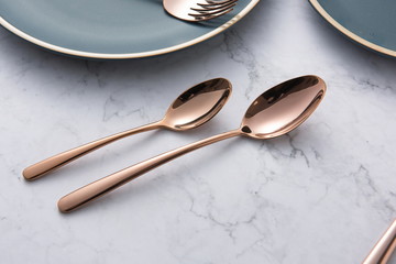 The golden tableware used in the wedding is in the background of marble