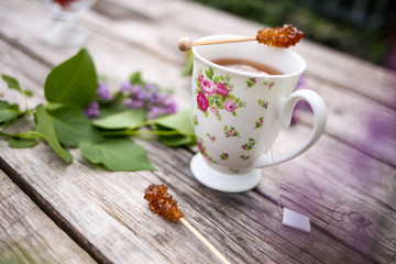 Morning beverage in the garden with flowers, fruit and tea