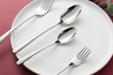 The silver tableware used for the wedding is on the red background
