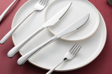 The silver tableware used for the wedding is on the red background