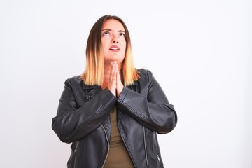 Young beautiful woman wearing t-shirt and jacket standing over isolated white background begging...