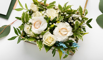 Obraz na płótnie Canvas Top view of creative wedding rings on bouquet