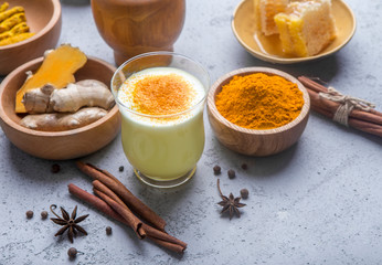 Tasty hot turmeric curcuma milk in cup on blue table