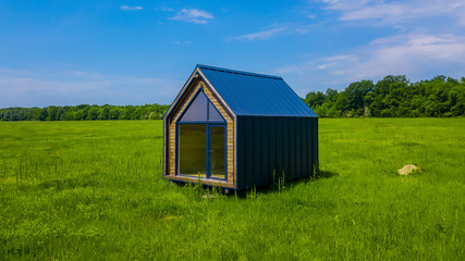Fototapeta na wymiar Modern one-story house in the middle of a green field
