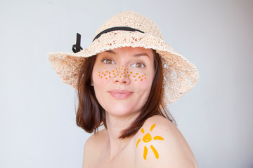  girl in a hat with freckles and the sun on his shoulder