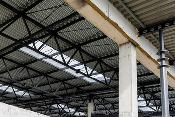 Aluminum roof with windows on a metal frame. Iron columns support the visor. Construction of the hangar.