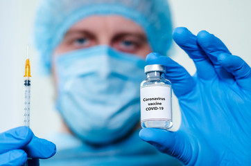 Male Nurs holding vaccine bottle with  Coronavirus vaccine.