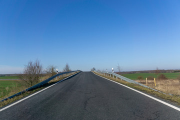 empty asphalt road to the horizon, cloudless blue sky, in Germany near Dresden