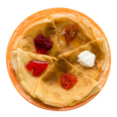 Pancakes on a plate with different toppings isolated on white.