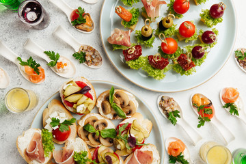 portioned snacks canapes and sandwiches with meat, cheese and vegetables
