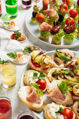 portioned snacks canapes and sandwiches with meat, cheese and vegetables