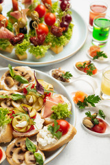 Fototapeta na wymiar portioned snacks canapes and sandwiches with meat, cheese and vegetables