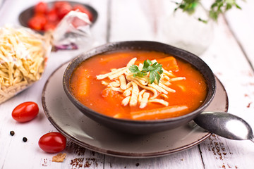 Tomato soup with noodles on a wooden table