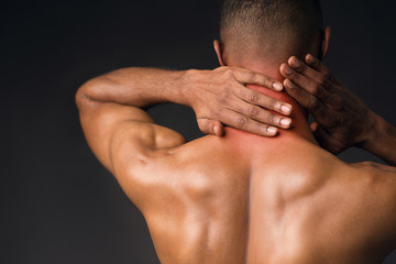 Shirtless black man suffering from pain in neck