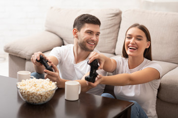 Happy Millennial Couple Playing Videogames Having Fun At Home