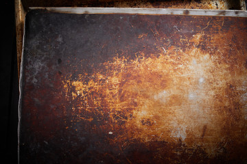Old baking tray surface with grungy brown coating