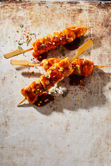 Three spicy marinated chicken kebabs with chili