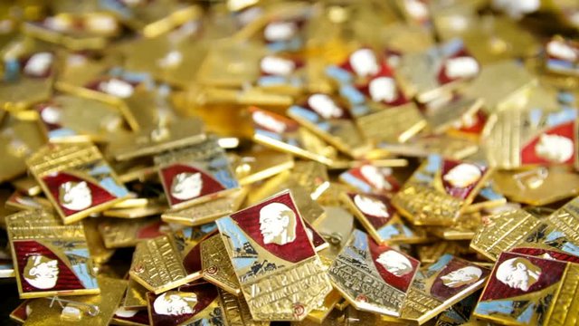 Zaporizhia, Ukraine - February 12, 2019. Background from the Komsomol badges of the USSR. Old metal pin with Lenin